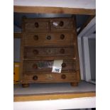 A table top six drawer chest.