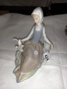 A seated Lladro girl with dove.