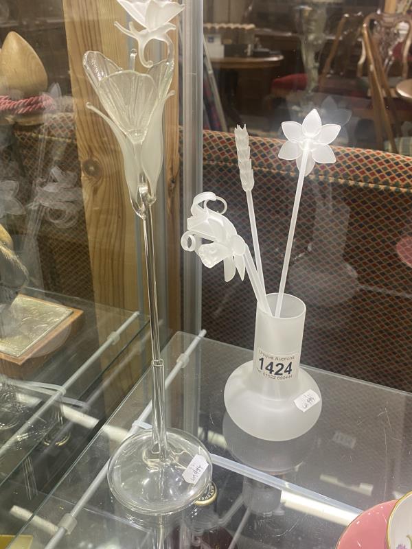 Two glass spill vases, one with four flower stems, one with a single flower and butterfly stem.