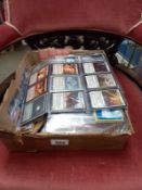 A box of Pokemon cards, magic the gathering cards, and a mix of graphic comics