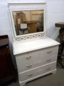 A white painted chest of drawers with mirror.