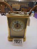 A brass carriage clock with key.