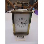 A brass carriage clock with key.