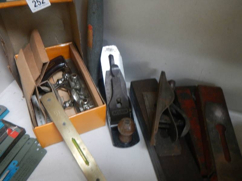 3 Wood planes, a grinding stone and a spirit level.