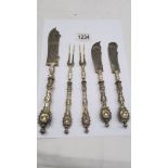 Three ornate knives and two ornate two prong forks.