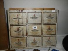 A wall box with 9 drawers and contents.