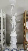A floor standing cherub lamp on plinth, COLLECT ONLY.