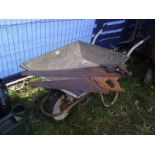 A galvanised wheelbarrow and two saws. COLLECT ONLY.
