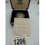 A cased 2000 silver proof £1 UK coin with certificate.