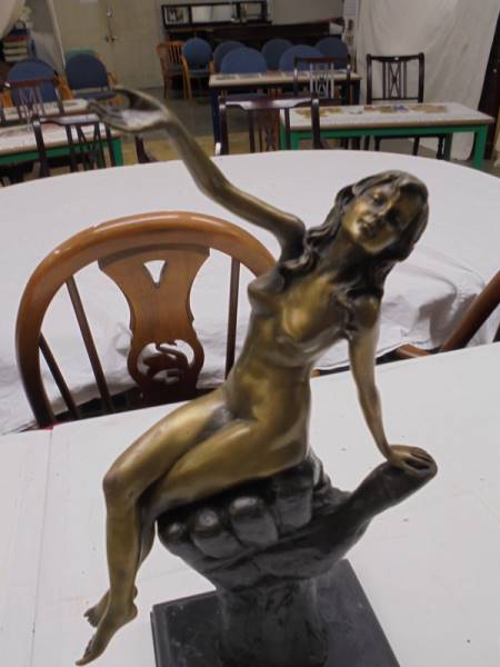 A bronze nude figure sitting on a hand on a marble base. - Image 2 of 2