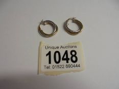 A pair of Italian 9ct two colour gold hoop earrings in swirl design. Weight 1.7g.