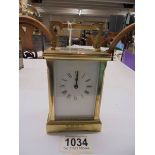 A brass carriage clock with key.