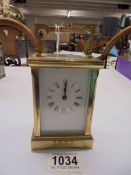 A brass carriage clock with key.