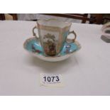 A continental porcelain hand painted two handled tea cup with saucer.