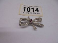 An 18ct white gold ruby and diamond bow brooch, 5.3 grams.