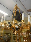 A Victorian Adam style brass and glass chandelier surmounted with cherubs. COLLECT ONLY.