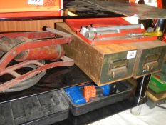 A shelf including old foot pump, metal drawers etc.