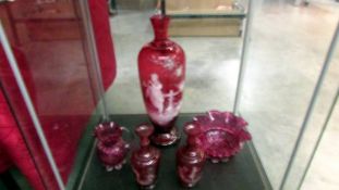 A Cranberry glass 'Mary Gregory' style vase, a similar smaller pair and a cranberry glass sugar bowl