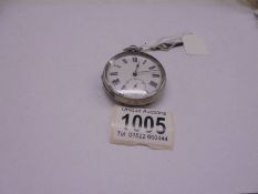 A silver pocket watch with key.