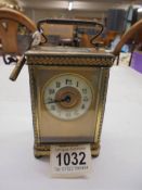 A brass carriage clock with key.