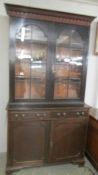 A Victorian mahogany bookcare with astragal glazed doors, cupboard base and dental cornice.