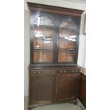 A Victorian mahogany bookcare with astragal glazed doors, cupboard base and dental cornice.