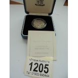 A cased 2000 silver proof £1 UK coin with certificate.