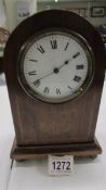 A mahogany inlaid mantel clock.