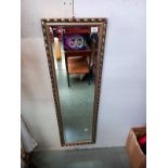 A gilt framed bevelled edge mirror. 37cm x 124cm.