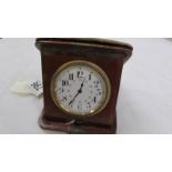 A vintage travel clock in leather case, in working order.