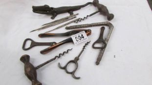 A vintage cast iron crocodile nut cracker, cork screws and bottle openers.