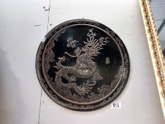 An embossed oriental tin wall plaque of a dragon. Diameter 39cm.