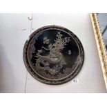 An embossed oriental tin wall plaque of a dragon. Diameter 39cm.