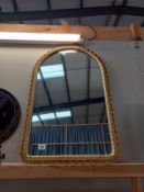 An ornate gilt framed arched mirror. 52cm x 83cm.