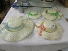 Four ceramic wall bonnets.