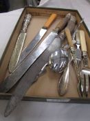 A selection of antique carving knives and other cutlery.