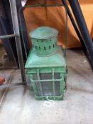 A green painted metal candle lantern.