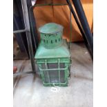 A green painted metal candle lantern.