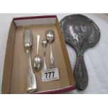 A silver backed hand mirror and a silver spoon.