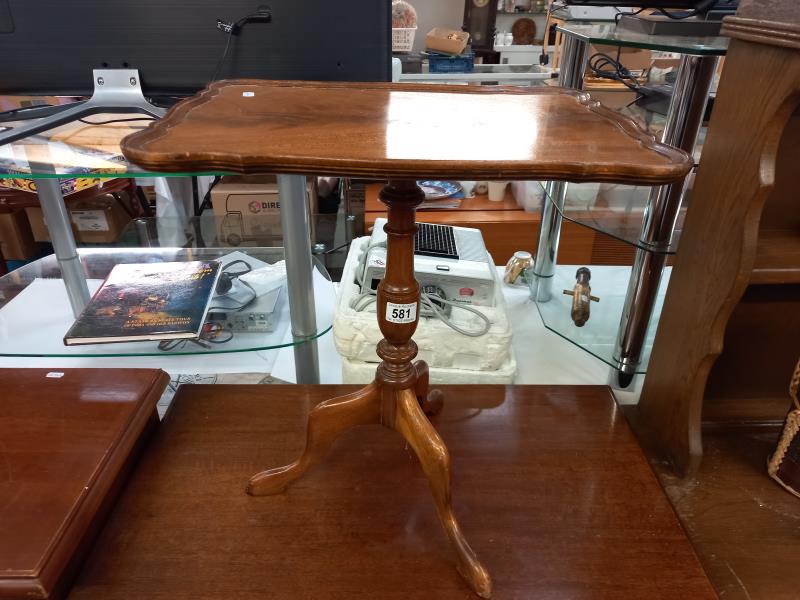 A vintage mahogany tea table with tripod base.