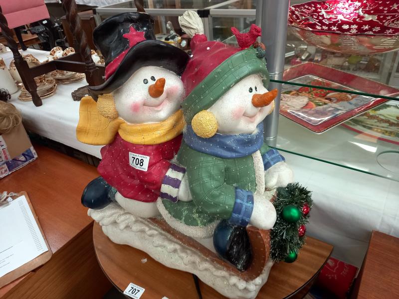 A Christmas decoration of 2 Snowmen figures on a sledge
