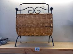 A wrought iron and wicker magazine rack.