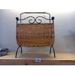 A wrought iron and wicker magazine rack.