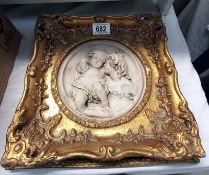 A gilded plaque with mother & child in the centre