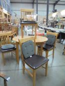 A light oak extending dining table and four chairs. COLLECT ONLY