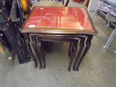 A nest of three glass top tables.