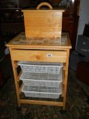 A pine kitchen unit with three baskets and a bread bin.