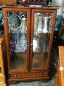 A good quality display cabinet with cut glass door and single drawer.