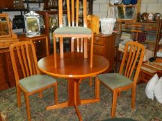 A good clean teak extending dining table with four matching chairs.