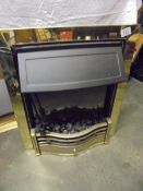 An electric coal effect fire with brass surround.